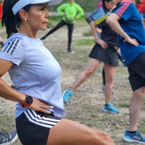 Mujer realizando ejercicios de estiramiento antes de correr como parte de su entrenamiento para la mmB