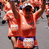 Mujer feliz corriendo la media maratón de Bogotá