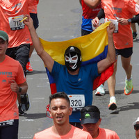 Corredor con bandera de Colombia cruzando la meta