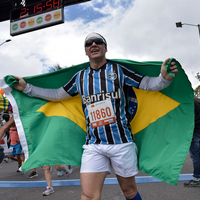 Corredor con bandera de Brasil cruzando la meta