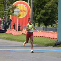 Mujer cruzando la línea de meta de la media maratón de Bogotá 2023