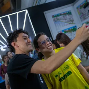 Corredores tomándose una foto con sus camisetas en la feria