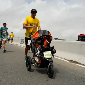 Participante corriendo junto a un bebe.