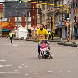 Participante con coche corriendo la maratón de atletismo