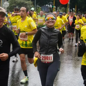 Mujer sonriente corriendo en asfalto