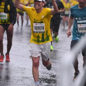 Atleta levantando los brazos celebrando tiempos media maraton