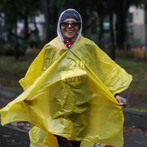 Mujer corriendo con poncho la carrera atletica bogota