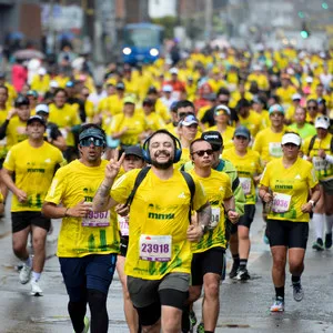 Hombre sonriendo a la cámara mientras usa audífonos