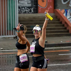 Dos mujeres corriendo y sonriendo en la media maratón de Bogotá