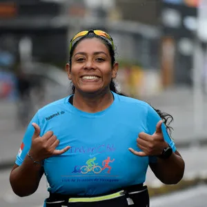 Mujer saludando a cámara corriendo por las calles de Bogotá