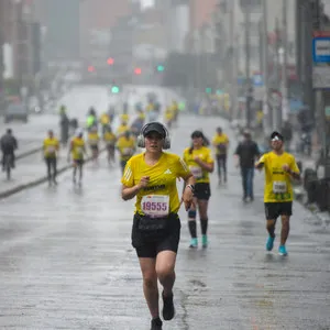 Mujer corriendo bajo la lluvia con audífonos