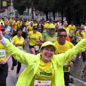 Mujer feliz con las manos arriba en carreras Bogotá