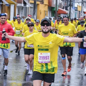 Hombre levantando los brazos en señal de triunfo en la media maratón