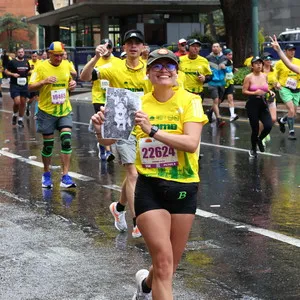 Mujer corriendo con foto de su perro la media maraton bogota