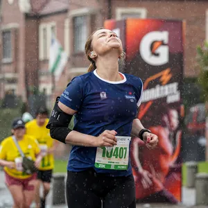 Atleta sintiendo la lluvia sobre la cara en la carrera de maraton