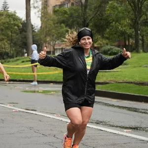 Mujer corriendo con chaqueta grande negra