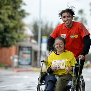 Participante en silla de ruedas con ayuda en la media maratón