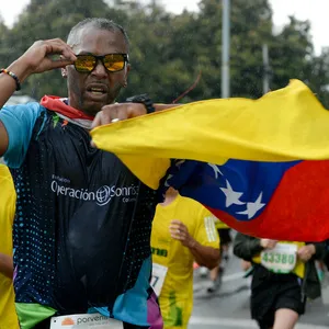 Atleta masculino corriendo con fuerza en la media maratón de Bogotá 2024