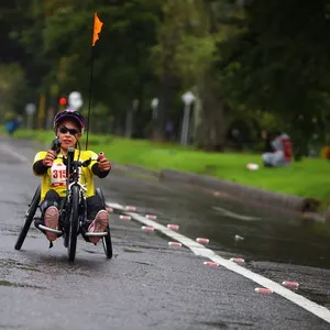 Atleta en silla de ruedas celebrando su esfuerzo en la carrera