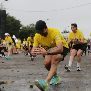 Participantes haciendo estiramientos dinámicos antes de la salida de la media maratón de Bogotá 2024