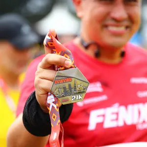 Atleta mostrando su medalla con orgullo después de la carrera atlética Bogotá