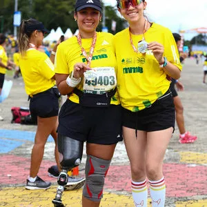 Atleta con prótesis mostrando su medalla en la carrera atlética hoy en Bogotá