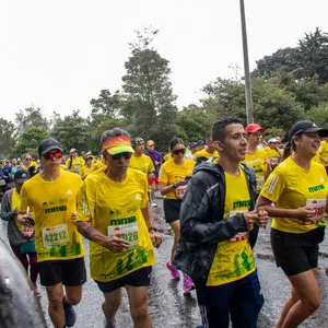 Hombre con gafas amarillas y gorra negra corriendo