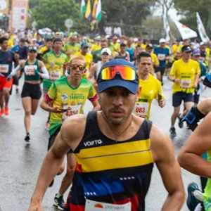 Hombre con gafas rojas y gorra azul corriendo en la mmB