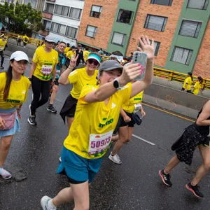 Mujer tomando fotografía junto a sus amigas mientras corre