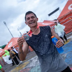 Atleta con cara de emoción enseña su medalla