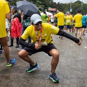 Hombre agachado posando con medalla