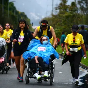 Mujer siendo apoyada por su familia próxima a cruzar meta