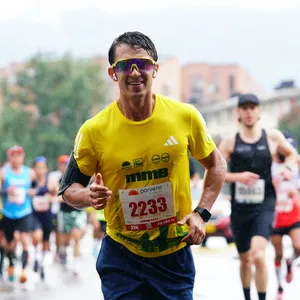 En las calles de Bogotá, hombre con gafas resalta en la masa de atletas