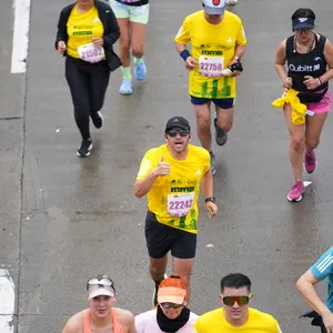 Hombre con la boca abierta saluda a cámara mientras corre