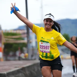 Mujer estira ambas manos de manera diagonal mientras sonríe