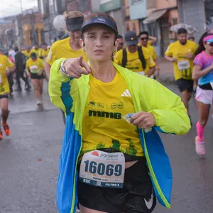 Mujer con bolsa de agua en la mano corre bajo la lluvia