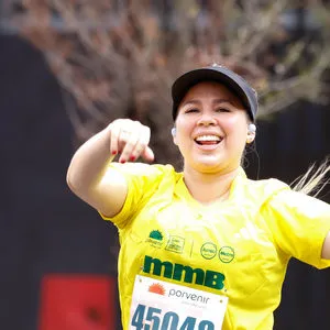 Mujer sonriendo mientras levanta la mano