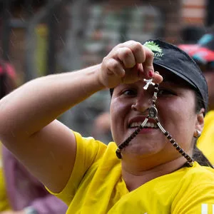 Mujer enseñando rosario a cámara