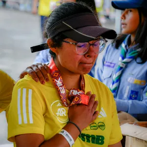 Mujer abrazando medalla con cara de alegría