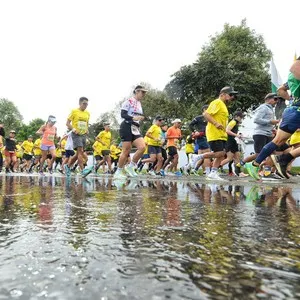 Desde el suelo sobre un charco se ve a todos los atletas