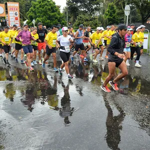 Atletas pasando junto a los charcos por lluvia