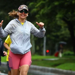 Mujer corriendo bajo la lluvia con chaqueta gris