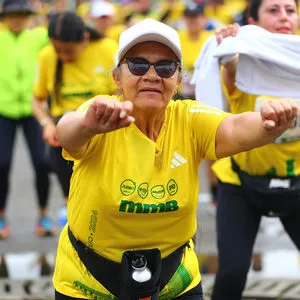 Mujer con gorra blanca estirando los brazos al frente