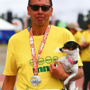 Hombre junto a su mascota después recorrido de 10 K