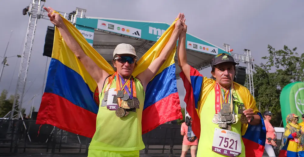 Dos hombres que participaron en la mmB 2023 muestran sus medallas