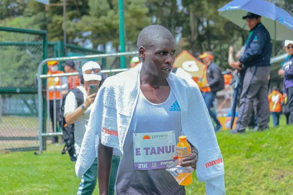 Hombre hidratando después de correr la media maratón de bogotá 2023