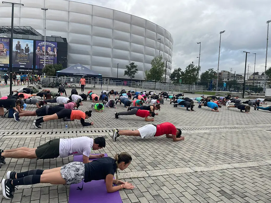 Grupo de corredores en el Parque Movistar Arena participando en un entrenamiento de la mmB