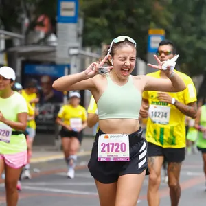 Mujer feliz corriendo la mmB, maraton atletismo