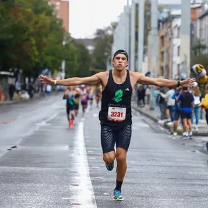 Participante levantando los brazos en señal de victoria en la maraton bogota