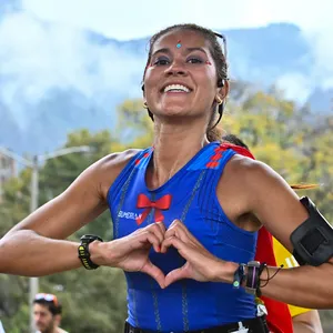 Mujer feliz corriendo la mmB, maraton atletismo